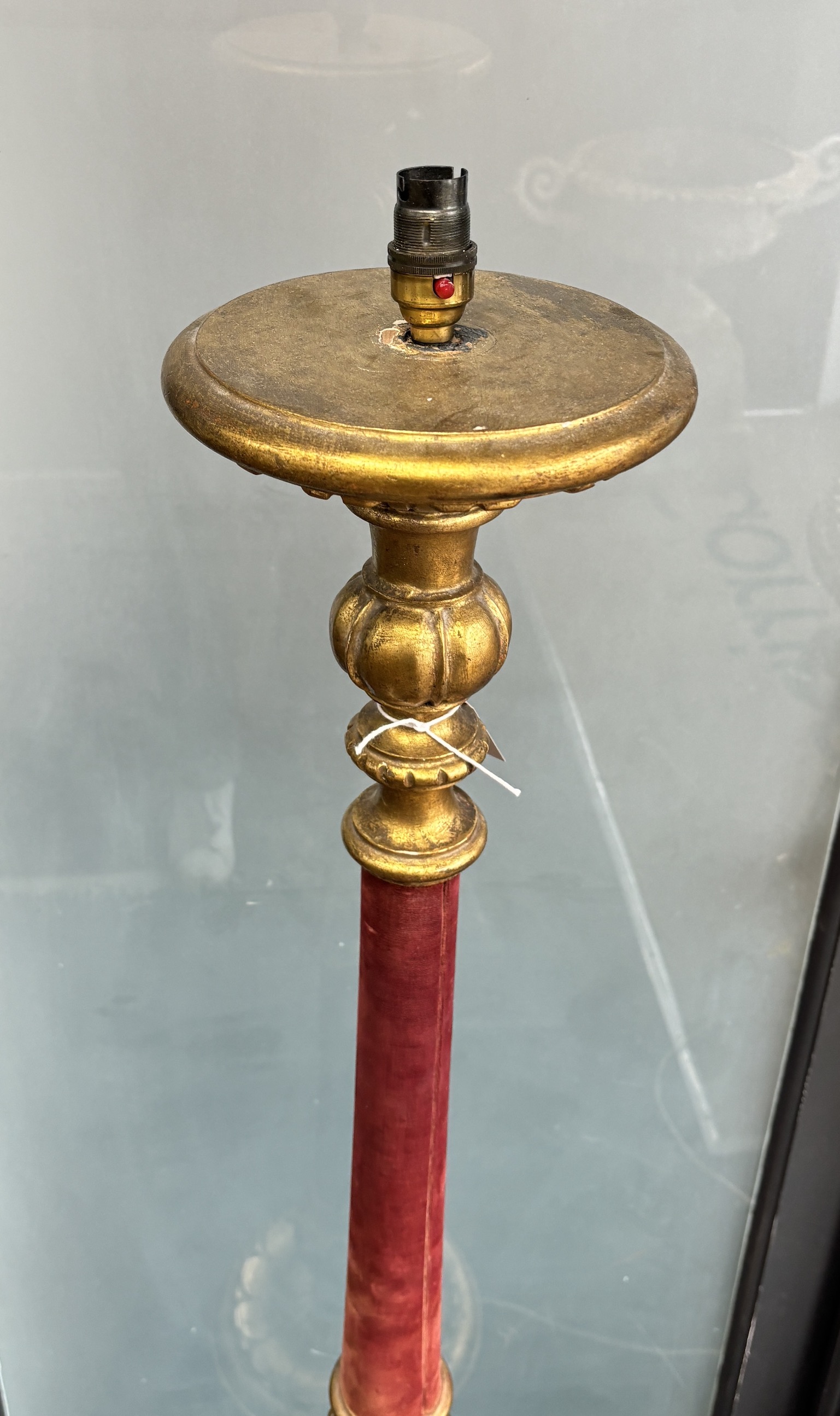 A gilt standard lamp with part fabric covered column
